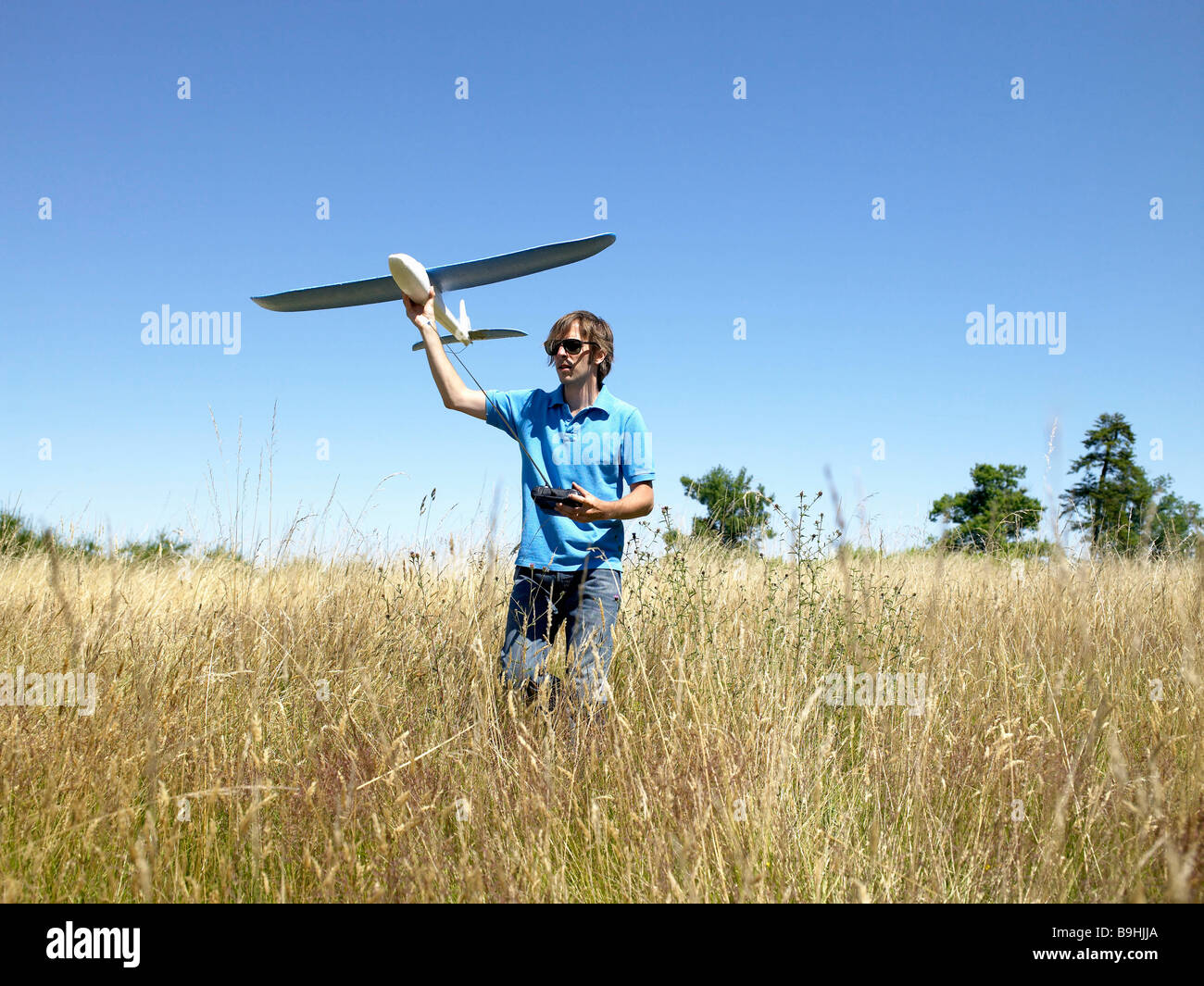 Man playing with remote-controlled plane Stock Photo