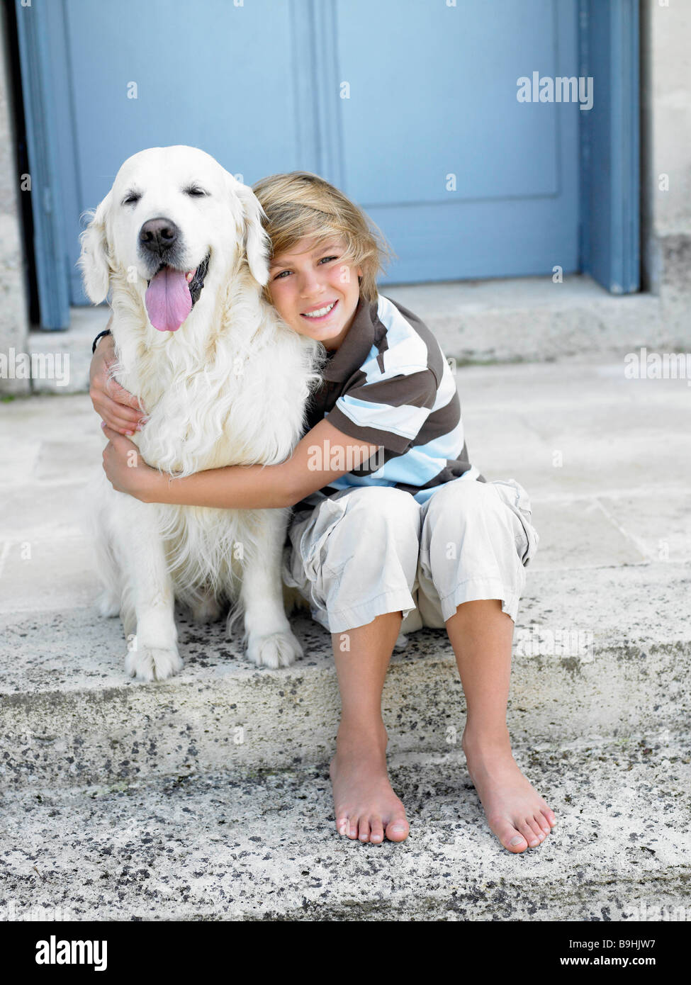 Boy with dog on door step Stock Photo