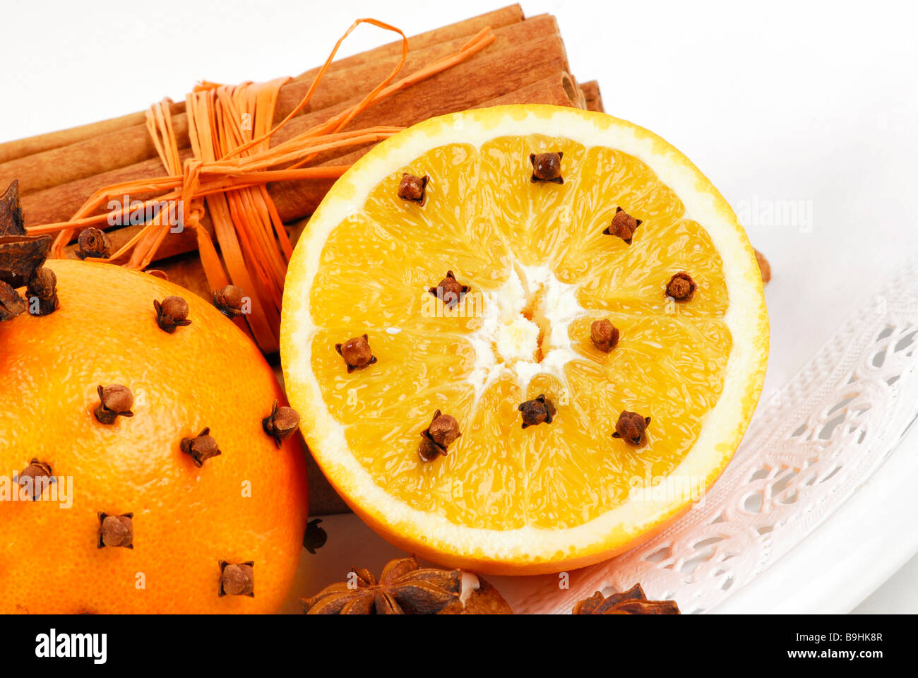Oranges studded with cloves and cinnamon sticks, aromatic christmas decoration Stock Photo