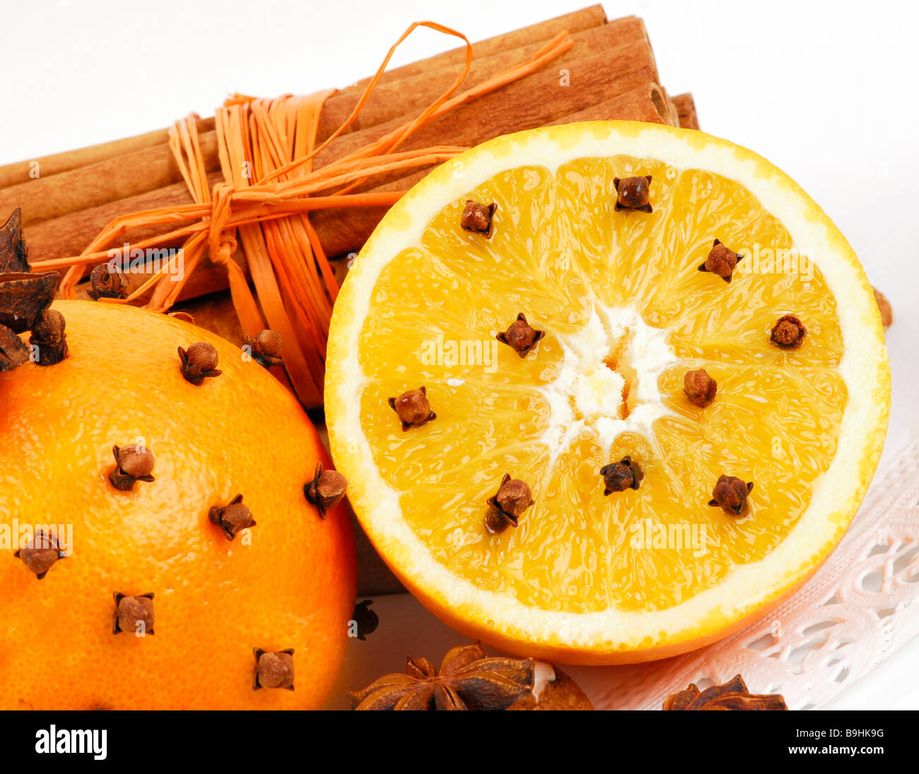 Oranges spiked with cloves, and cinnamon sticks, aroma and decoration Stock Photo
