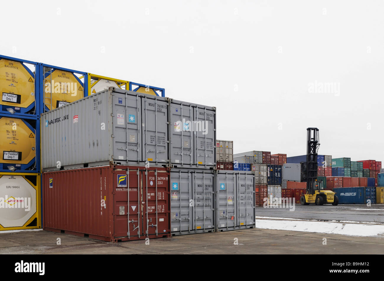 Container Terminal Bonn, standard and tank containers in front and a container forklift driving in the back, Bonn, North Rhine- Stock Photo