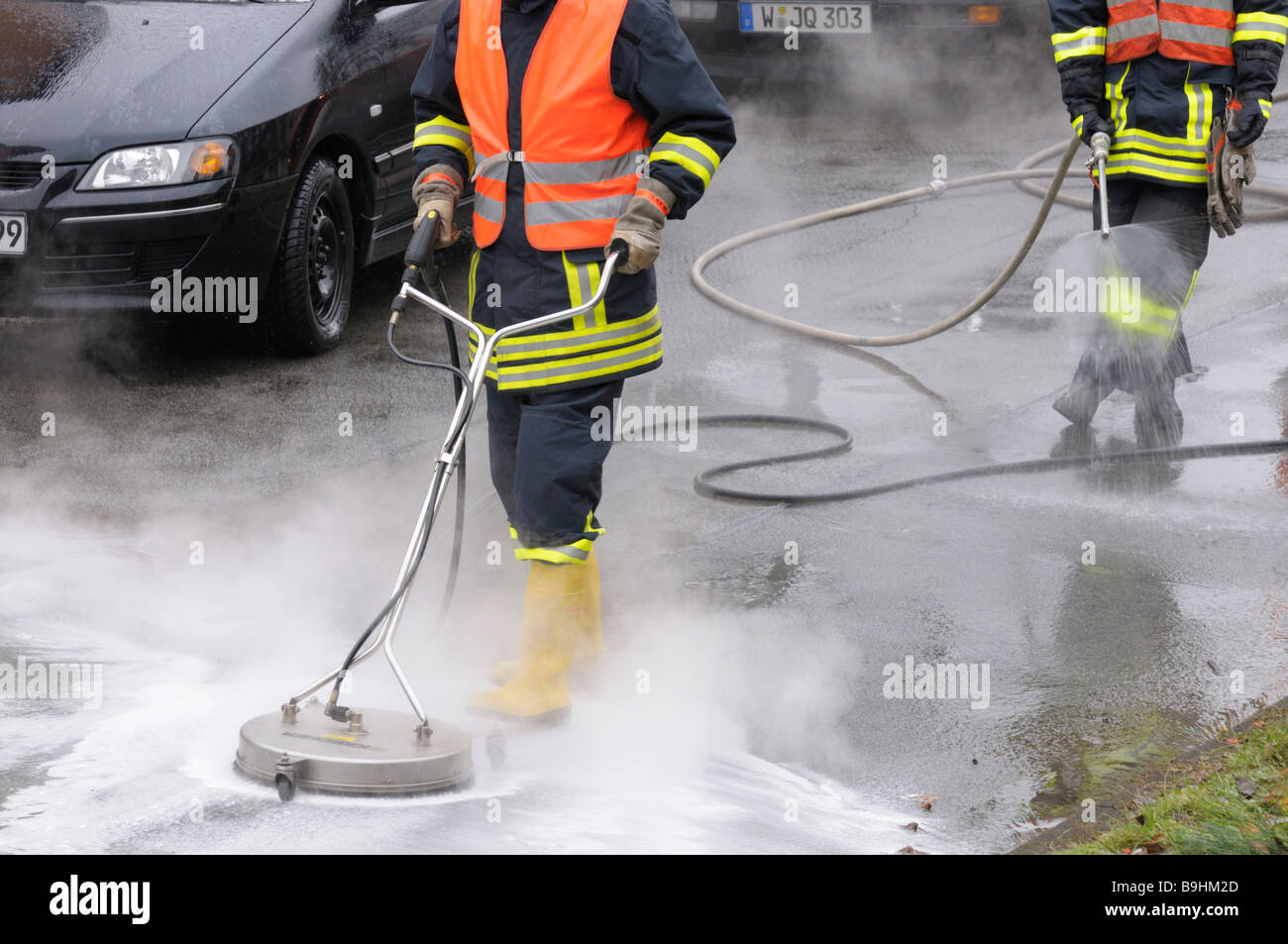 Fire brigade in action, neutralising leaked brake fluid with water