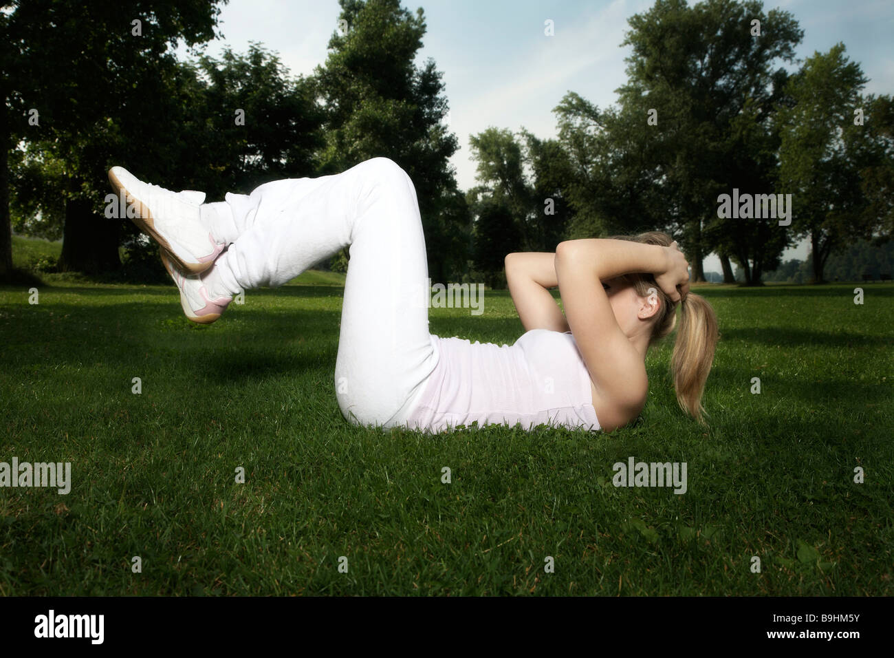 Young dark blonde woman exercising Stock Photo - Alamy