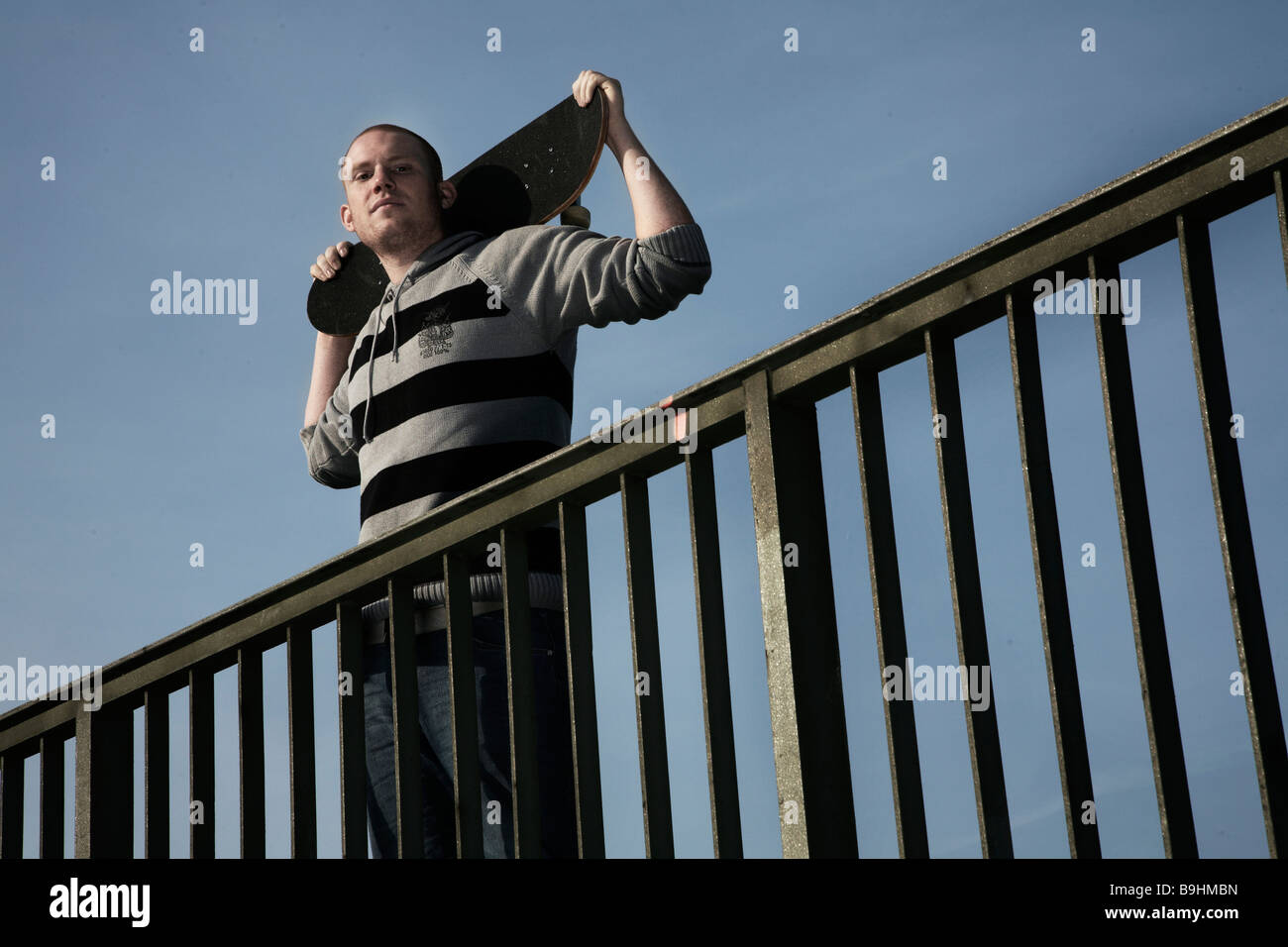 Young man with a skateboard on a railing Stock Photo Alamy