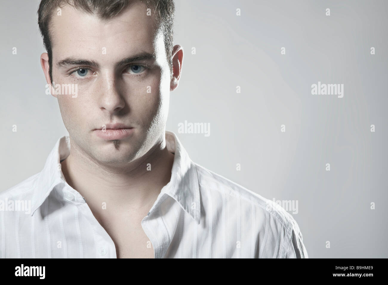 Portrait of a young man wearing a white shirt looking into camera Stock ...