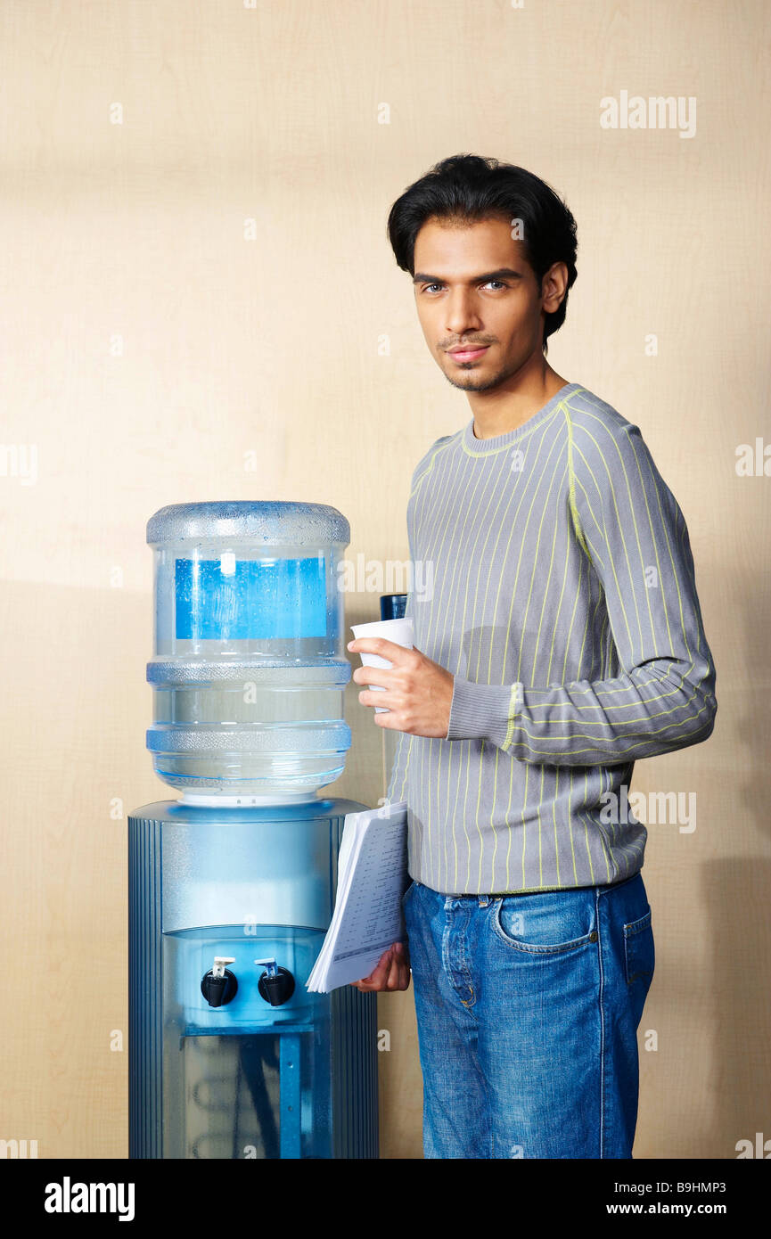 Man standing by water cooler Stock Photo