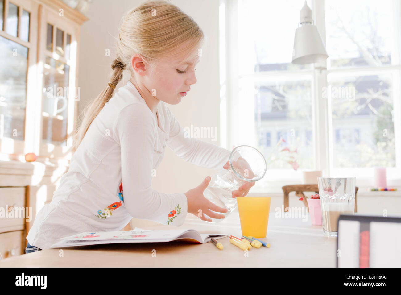 Girl pouring a glass of juice Stock Photo Alamy