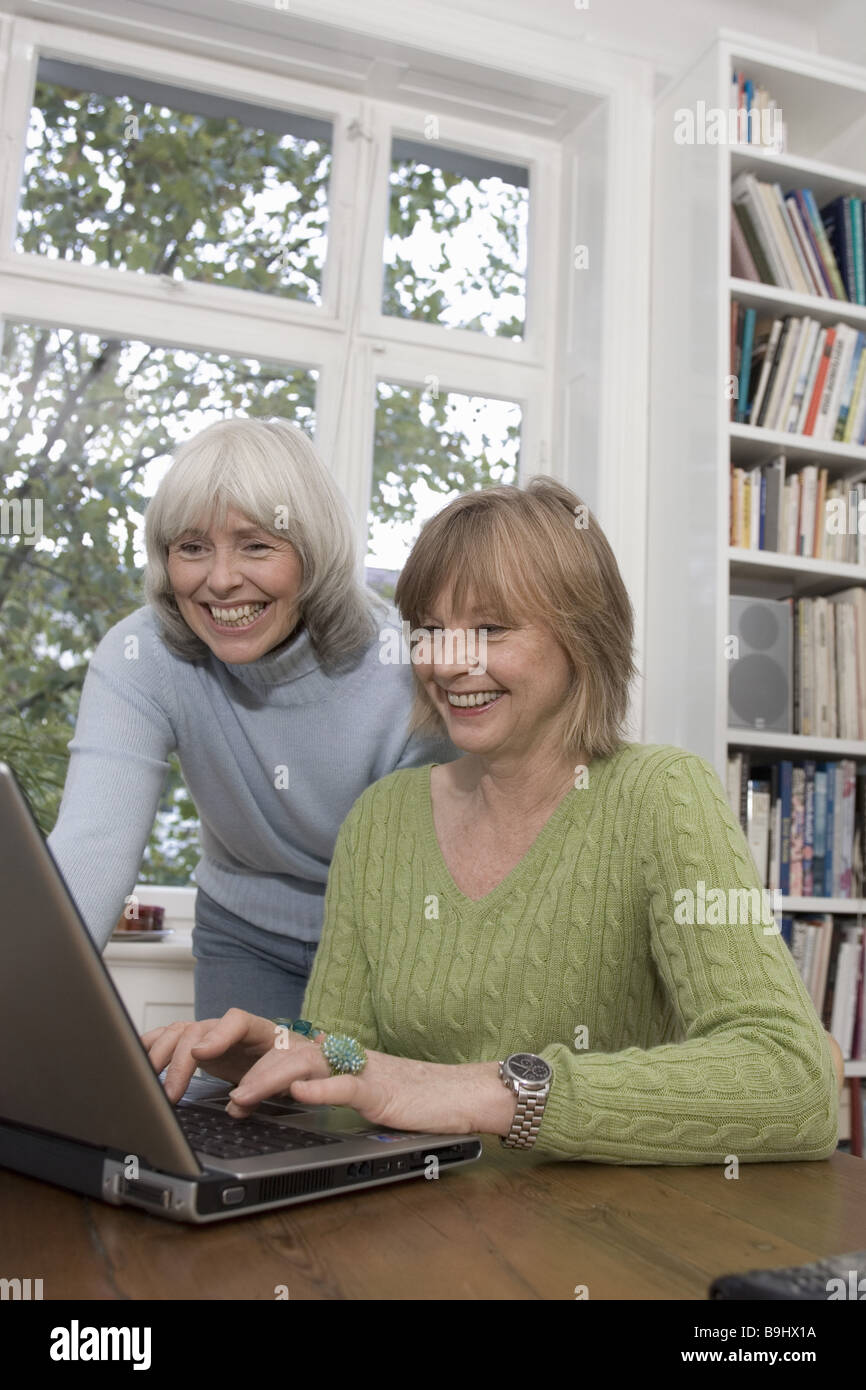 Seniors laptop data input laughs detail series people seniors women two cheerfully computers data processing internet surf the Stock Photo