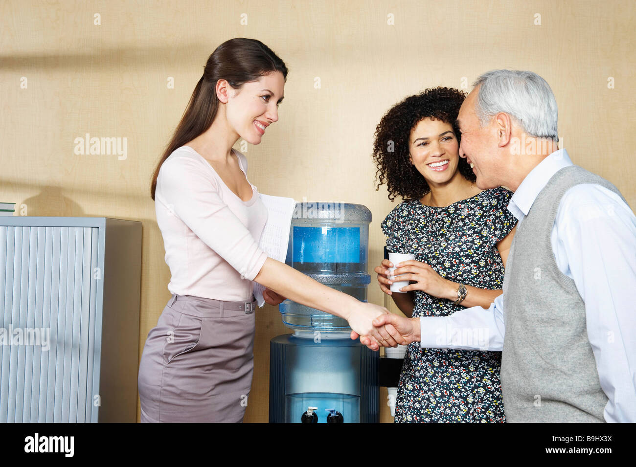 Casual meeting by office water cooler Stock Photo Alamy