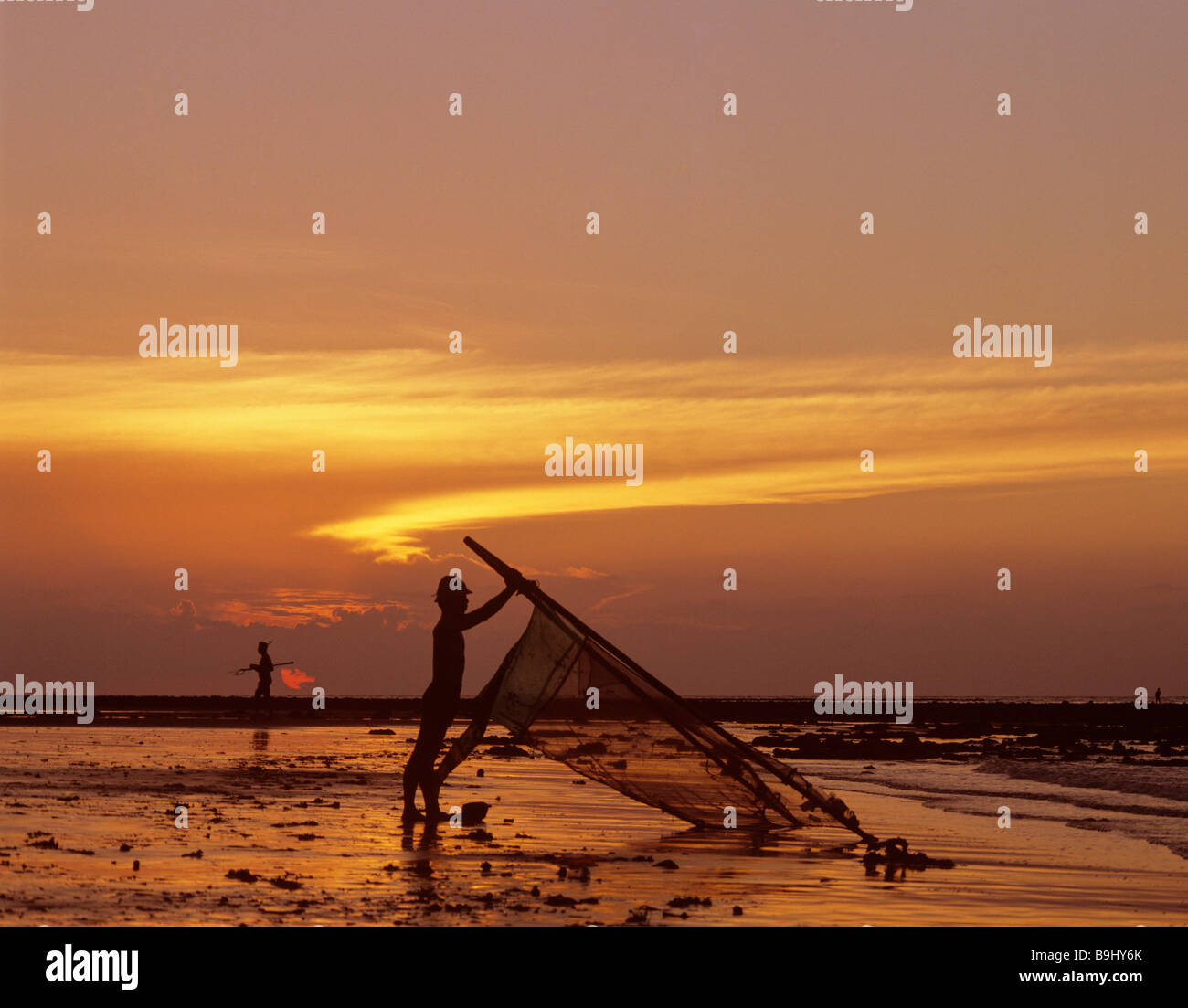 Fisherman with a net, ocean, evening light, Bali, Indonesia, south-east Asia Stock Photo