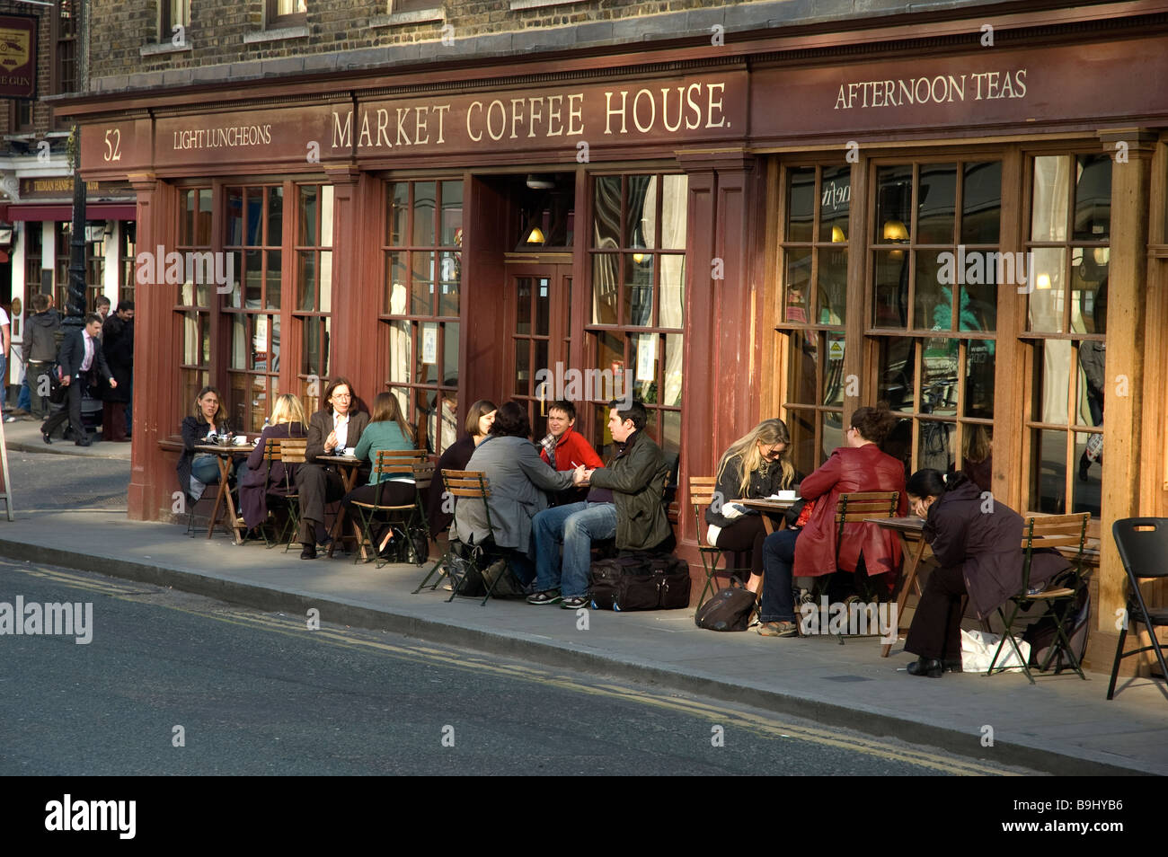 PEOPLE RELAX IN THE SUN OUTSIDE THE MARKET COFFEE HOUSE SPITALFIELS EAST LONDON Stock Photo
