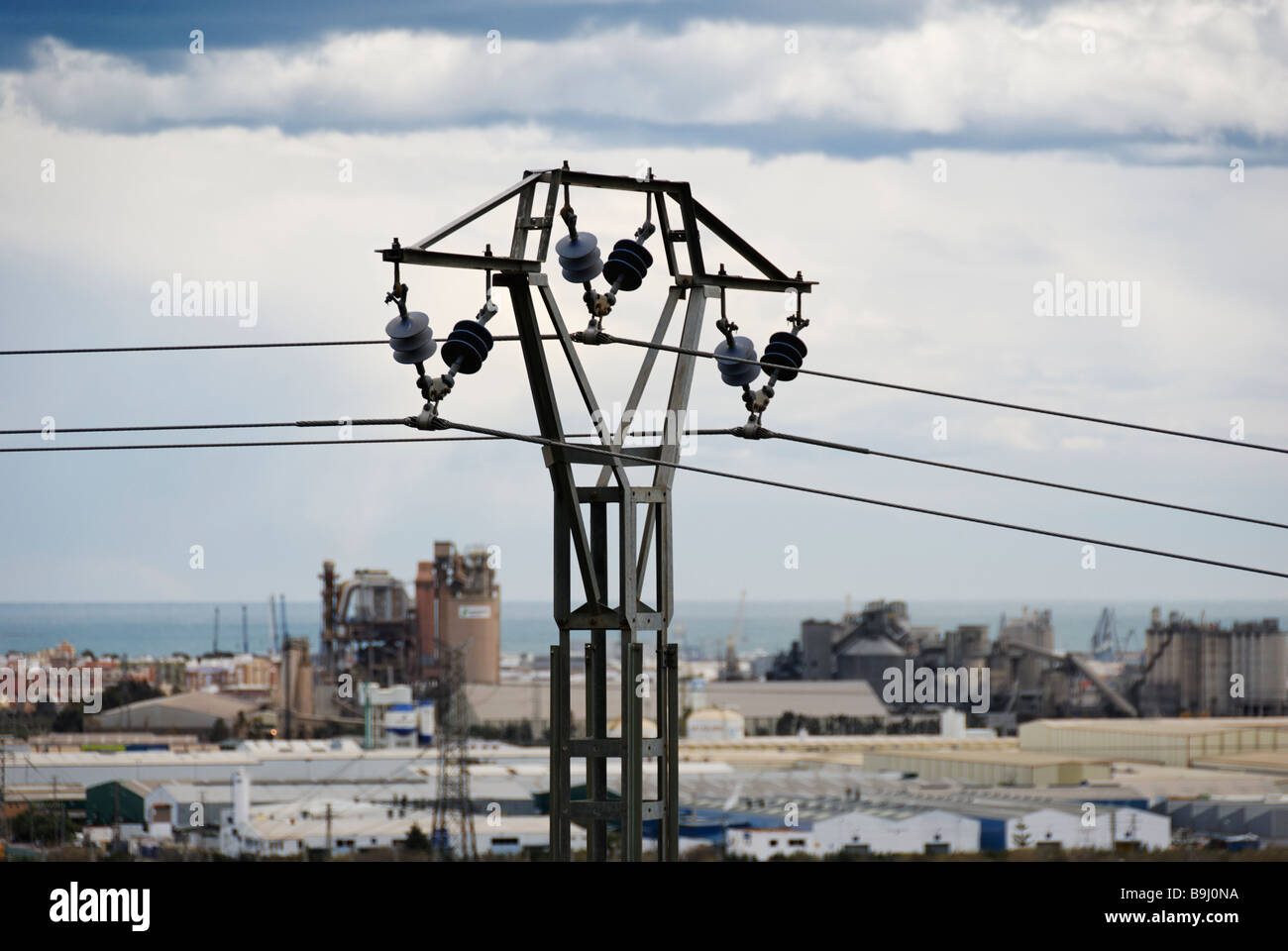 View of power line with industrialised Spanish coastline of the Costa Blanca in the background Region of Valencia Stock Photo