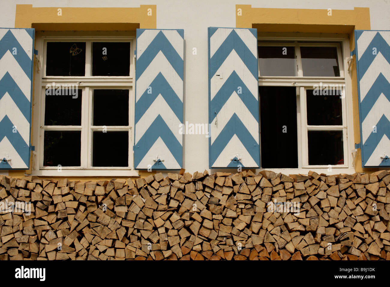 Bavarian house with wooden window shutters, firewood, Bavaria, Germany