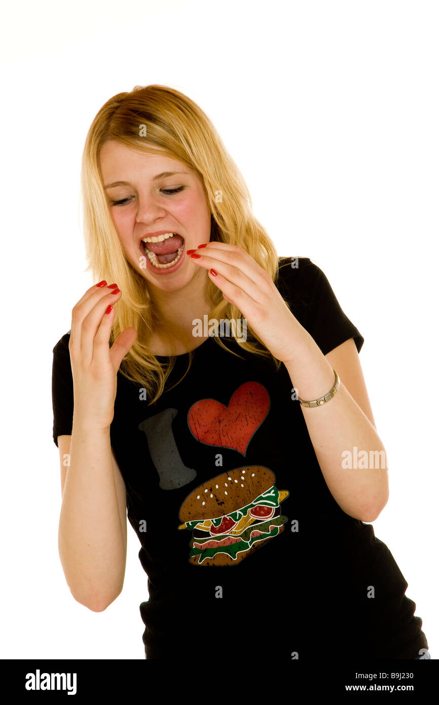 Thin 13-year-old girl wearing a t-shirt with a picture of a hamburger, eating an imaginary burger Stock Photo
