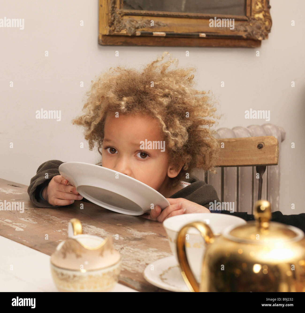 Young boy licking plate Stock Photo