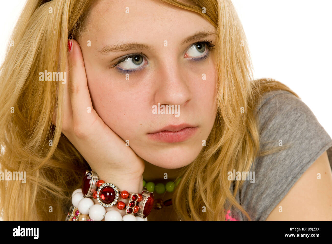 13-year-old girl leaning on her arm, dreamy or bored Stock Photo