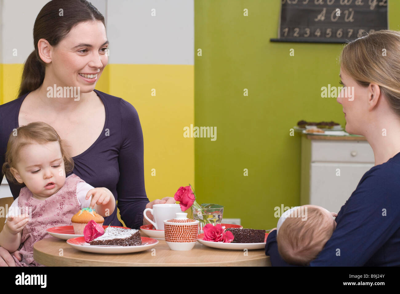 Two young mothers with their babies Stock Photo