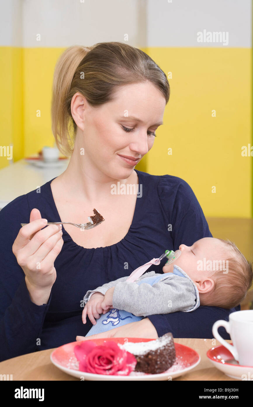 Young mother with baby,  eating cake Stock Photo