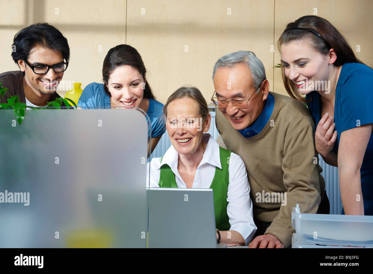 Group of people looking at laptop Stock Photo - Alamy