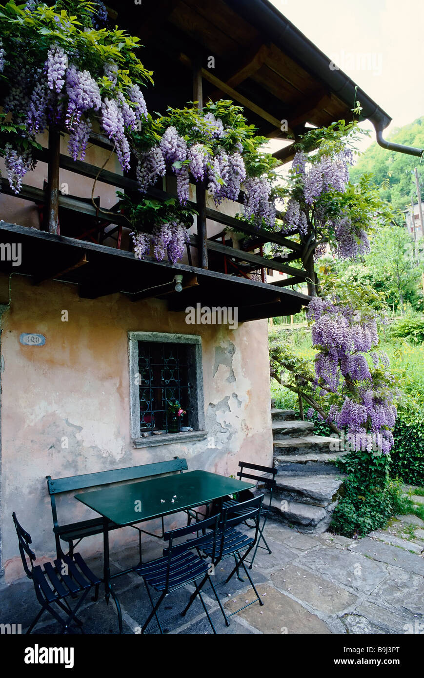 Idyllic house in Tessin, seat under a balcony with wisteria, Valle Onsernone, Canton of Tessin, Switzerland, Europe Stock Photo