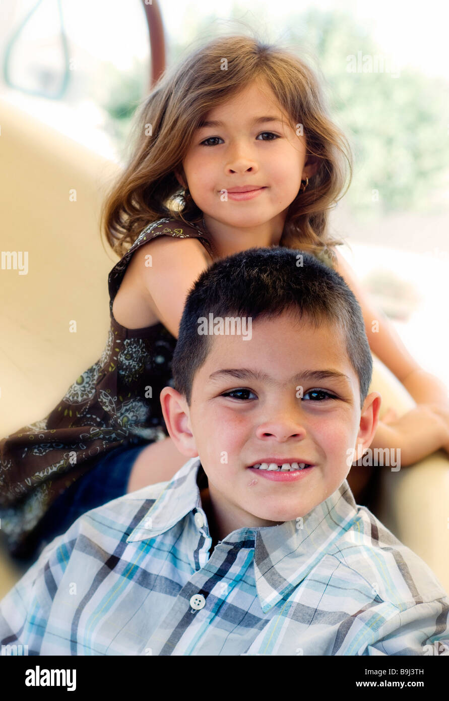 Brother and sister playing on slide in park Stock Photo - Alamy