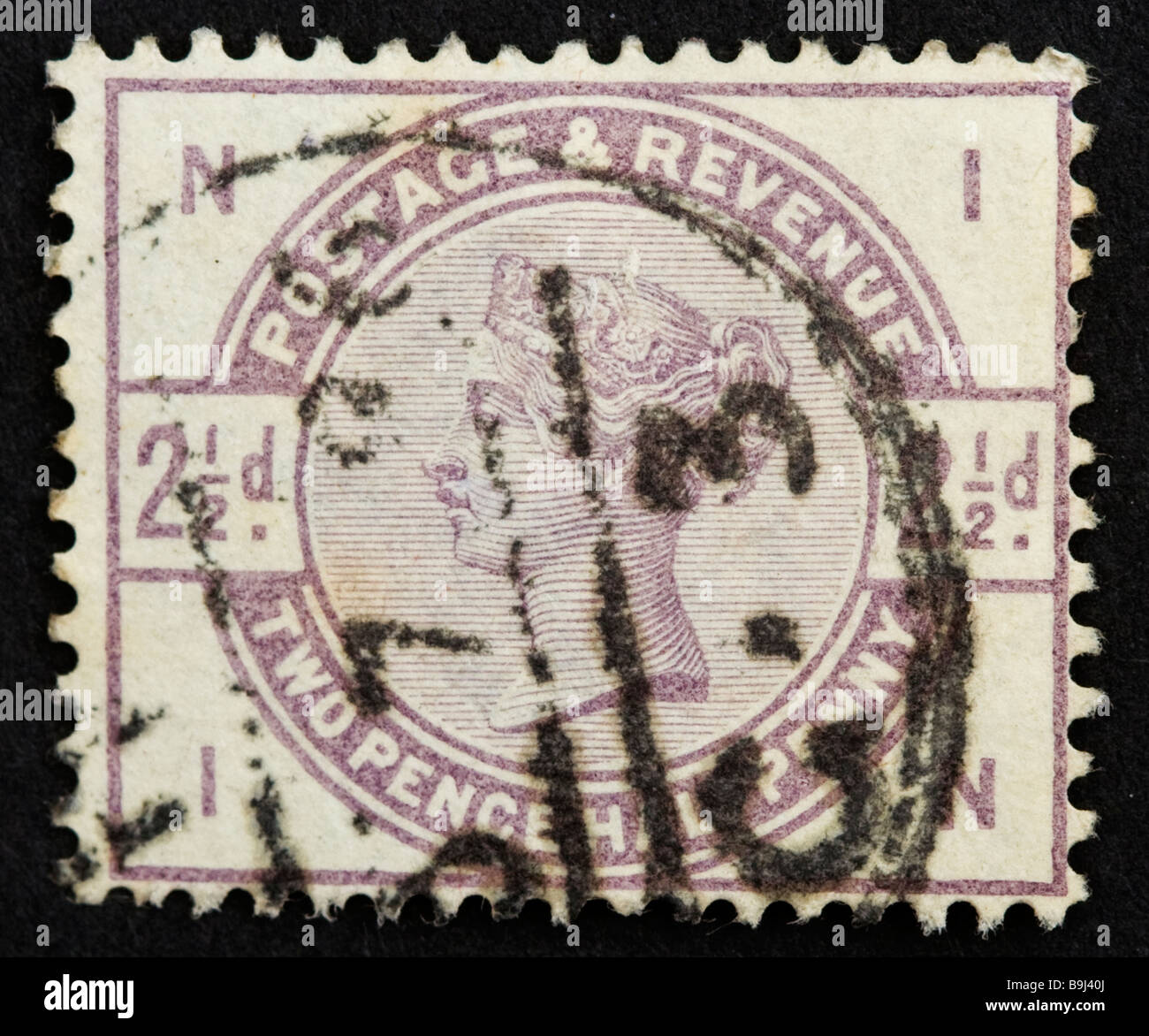 Close up of 2½d, lilac Victorian British Postal stamp on black background. Issued between 1883-4 SG 191 Unified issue Stock Photo