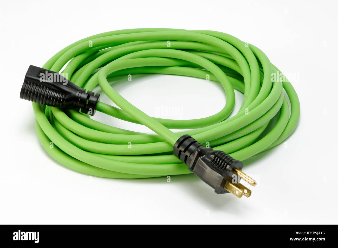 A coiled green electrical extension power cord with two plugs Stock Photo