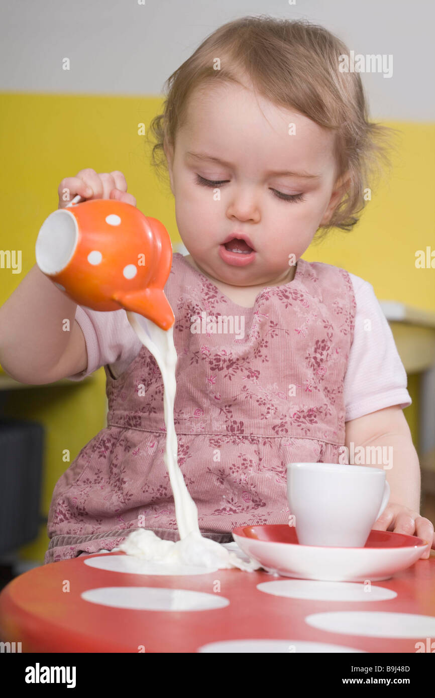 Young girl spilling milk on table Stock Photo Alamy