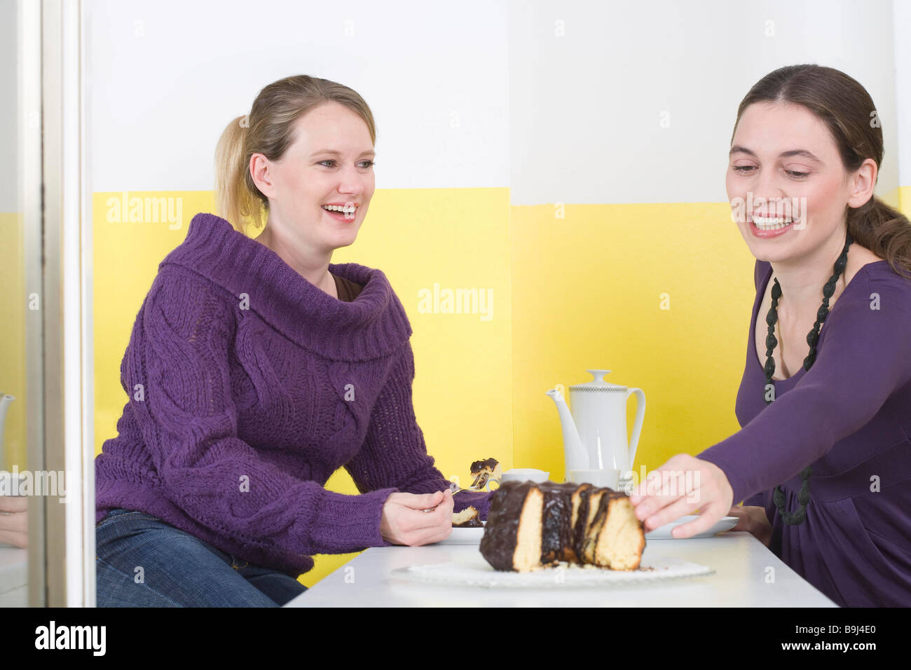 Two young women, eating cake Stock Photo Alamy