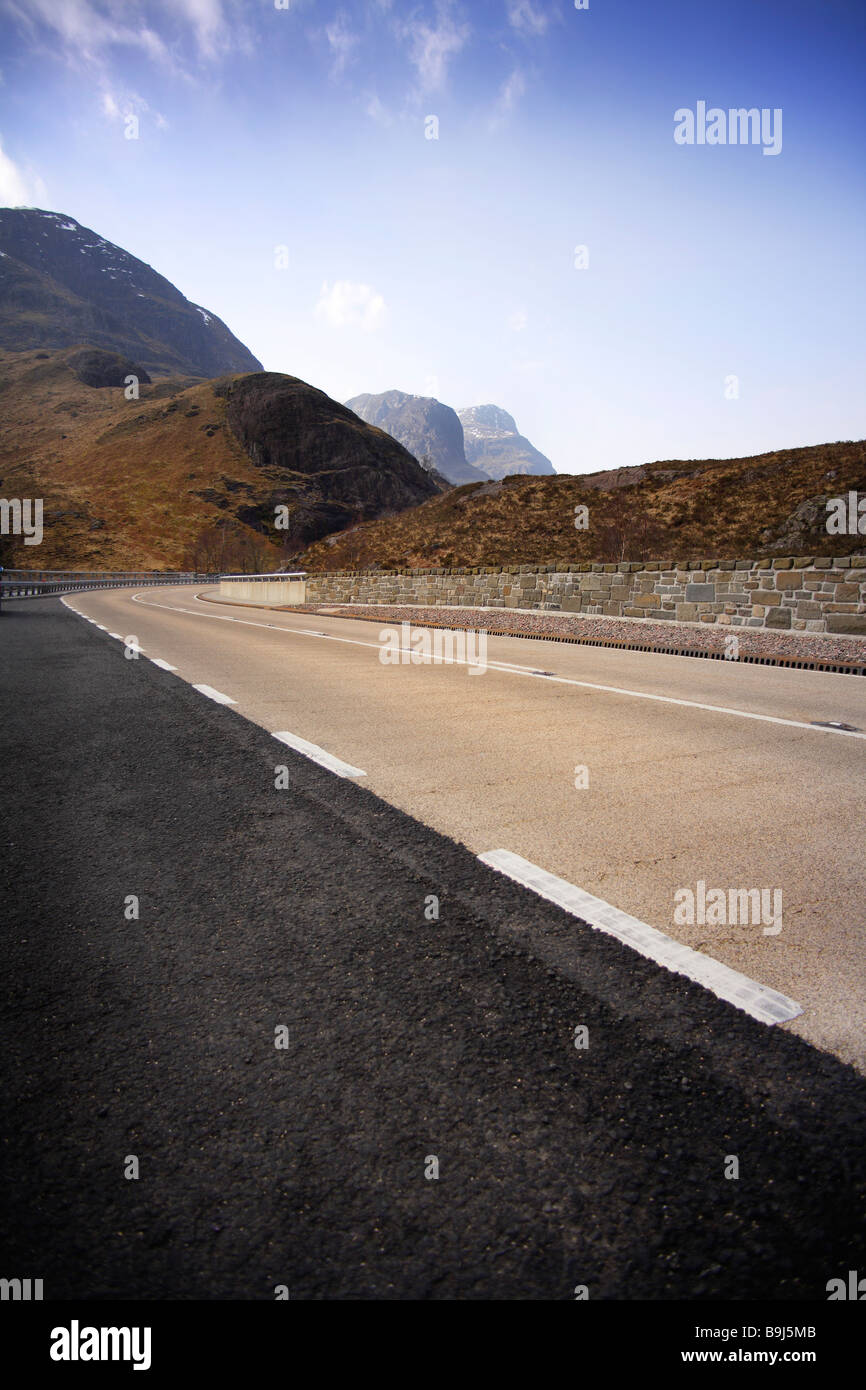 new road,sweeping curve,blue sky,no traffic. Stock Photo