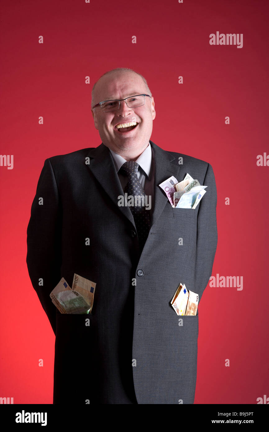 Businessman happy about his money-filled jacket pockets Stock Photo