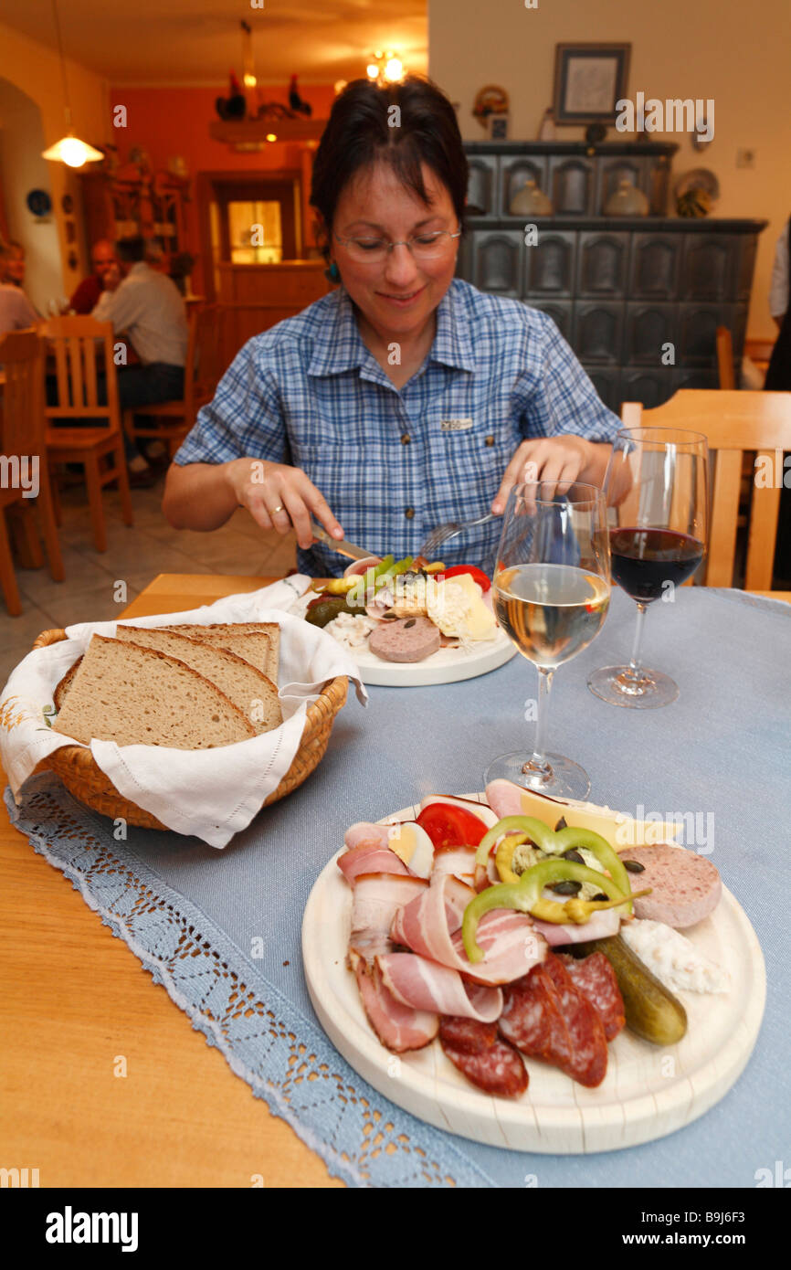 Woman having Brettljause, a hearty snack, in Buschenschank Kaiser, bar, Kitzeck, Styria, Austria, Europe Stock Photo