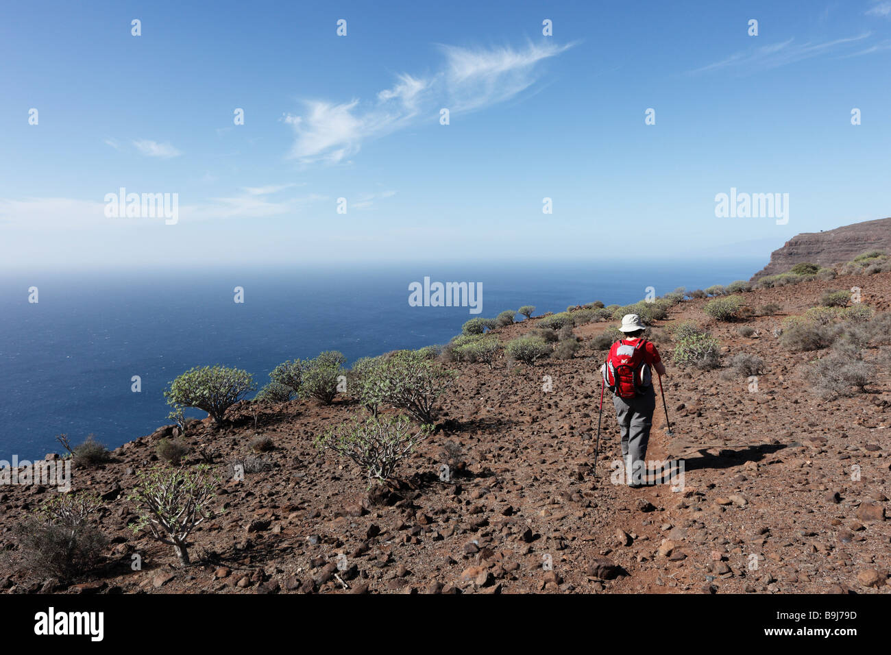 Woman with a rucksack and walking canes, Las Pilas, La Gomera, Canary Islands, Spain, Europe Stock Photo