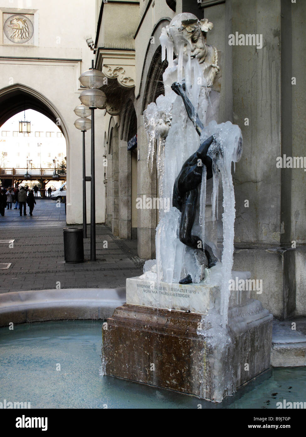 Frozen over Brunnenbuberl Fountain in Neuhauser Street in front of Karlstor Gate, Munich, Bavaria, Germany, Europe Stock Photo