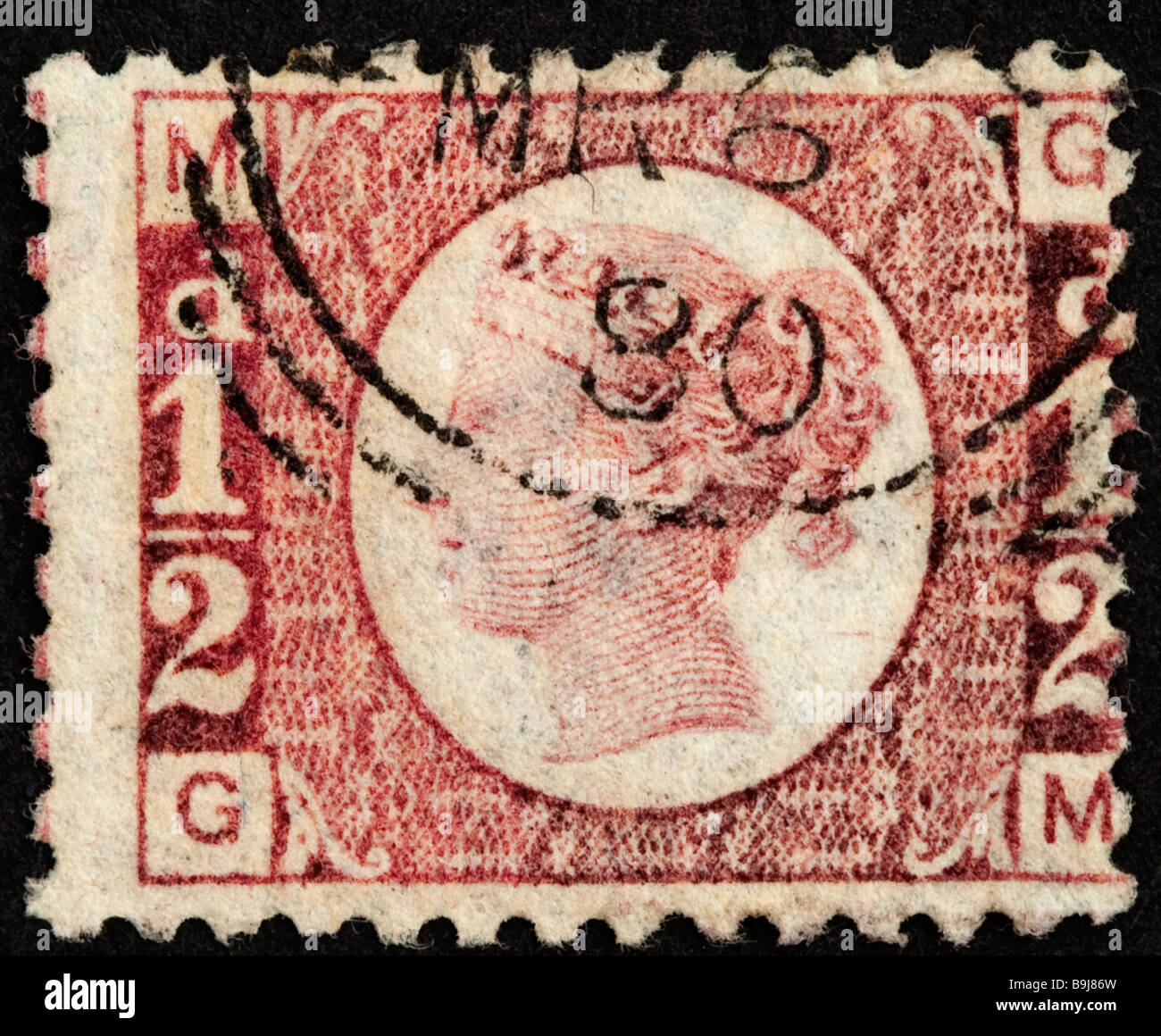 Close up of half penny red Victorian British Postal stamp on black background. Used with postmark, issued in 1870. SG 48. Stock Photo