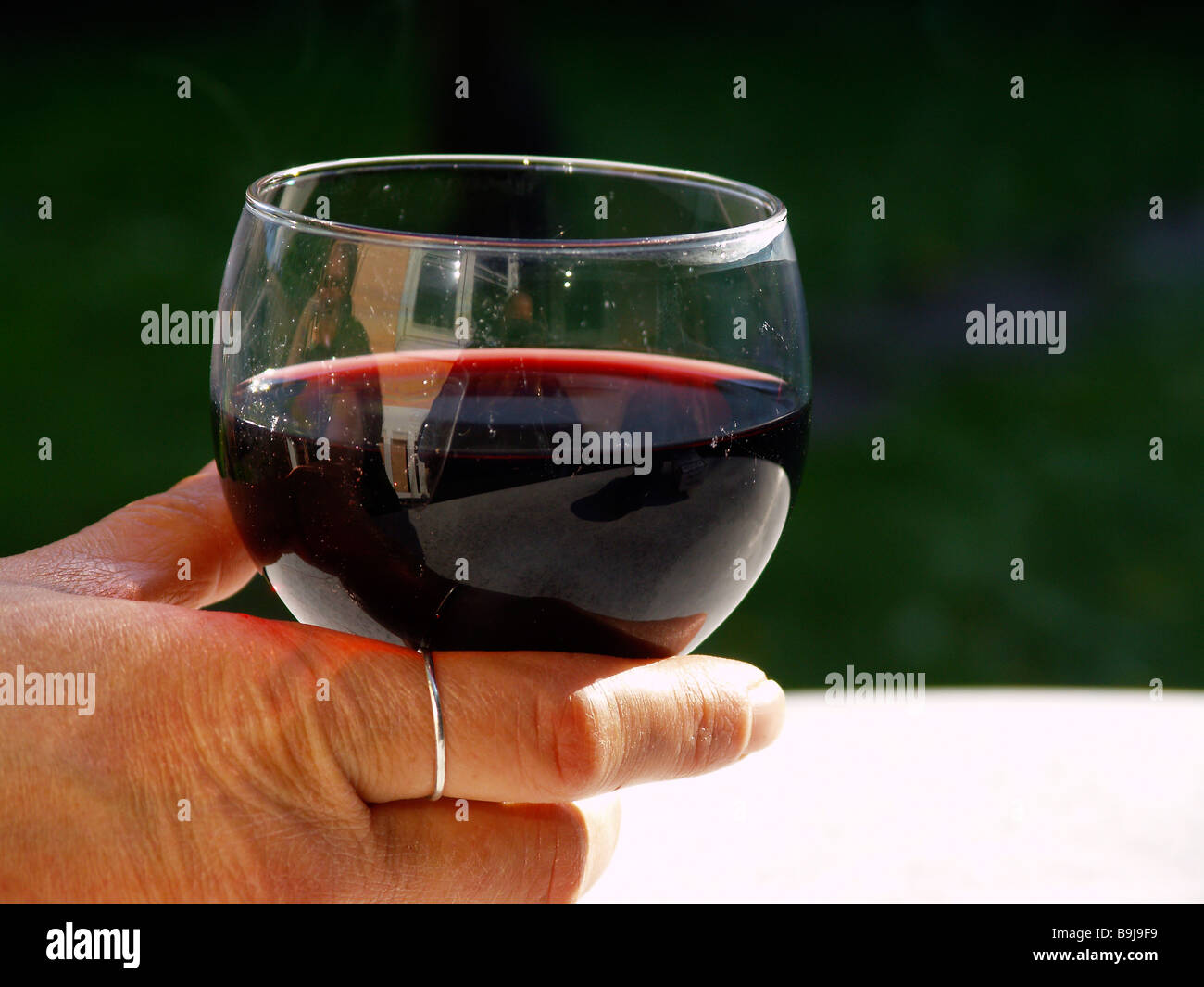 Holding glass of red wine Cut Out Stock Images & Pictures - Alamy