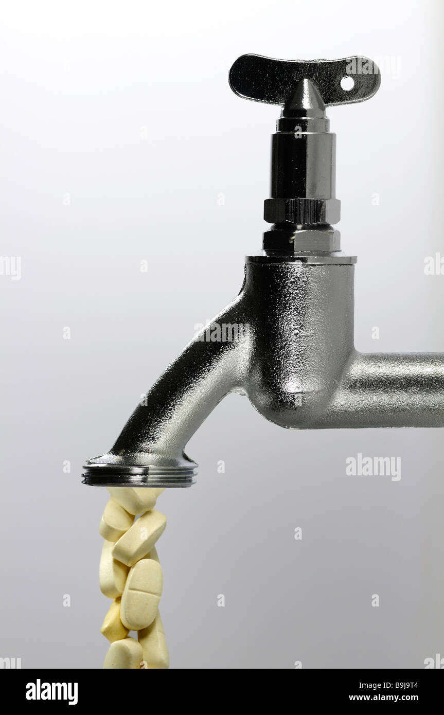 Tablets drop from water tap, symbolic of contamination of drinking water by medication, hormones, chemicals, contaminates Stock Photo
