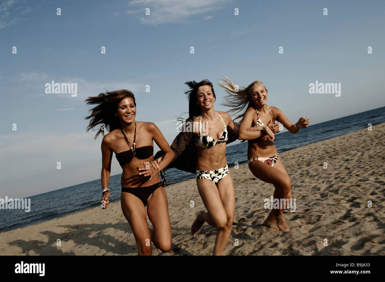 Girl teenagers running on the beach Stock Photo