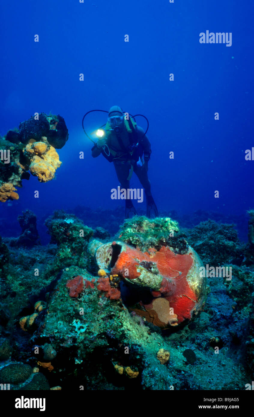 Scuba diver swimming above an Amphora overgrown with a red sponge, Mediterranean Sea, Turkey Stock Photo