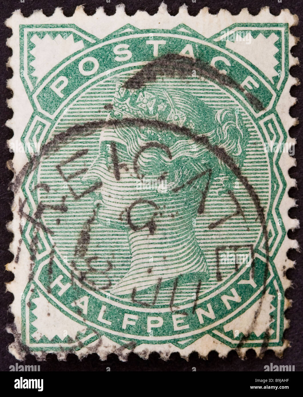 Close up of ½d, half penny green Victorian British Postal stamp on black background 1880 SG 164 used. Round postmarked Reigate. Stock Photo