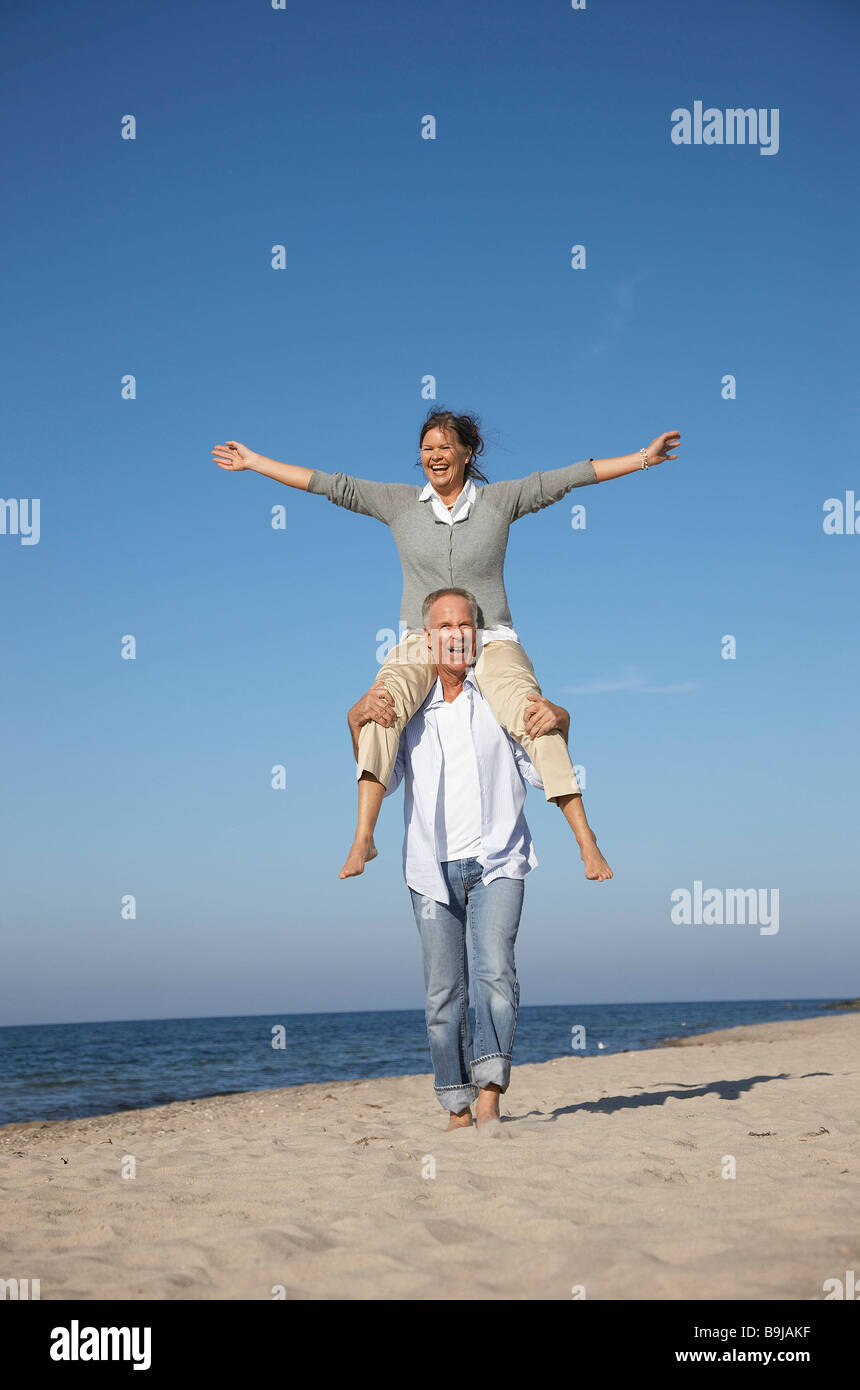 Mature couple walking along beach Stock Photo
