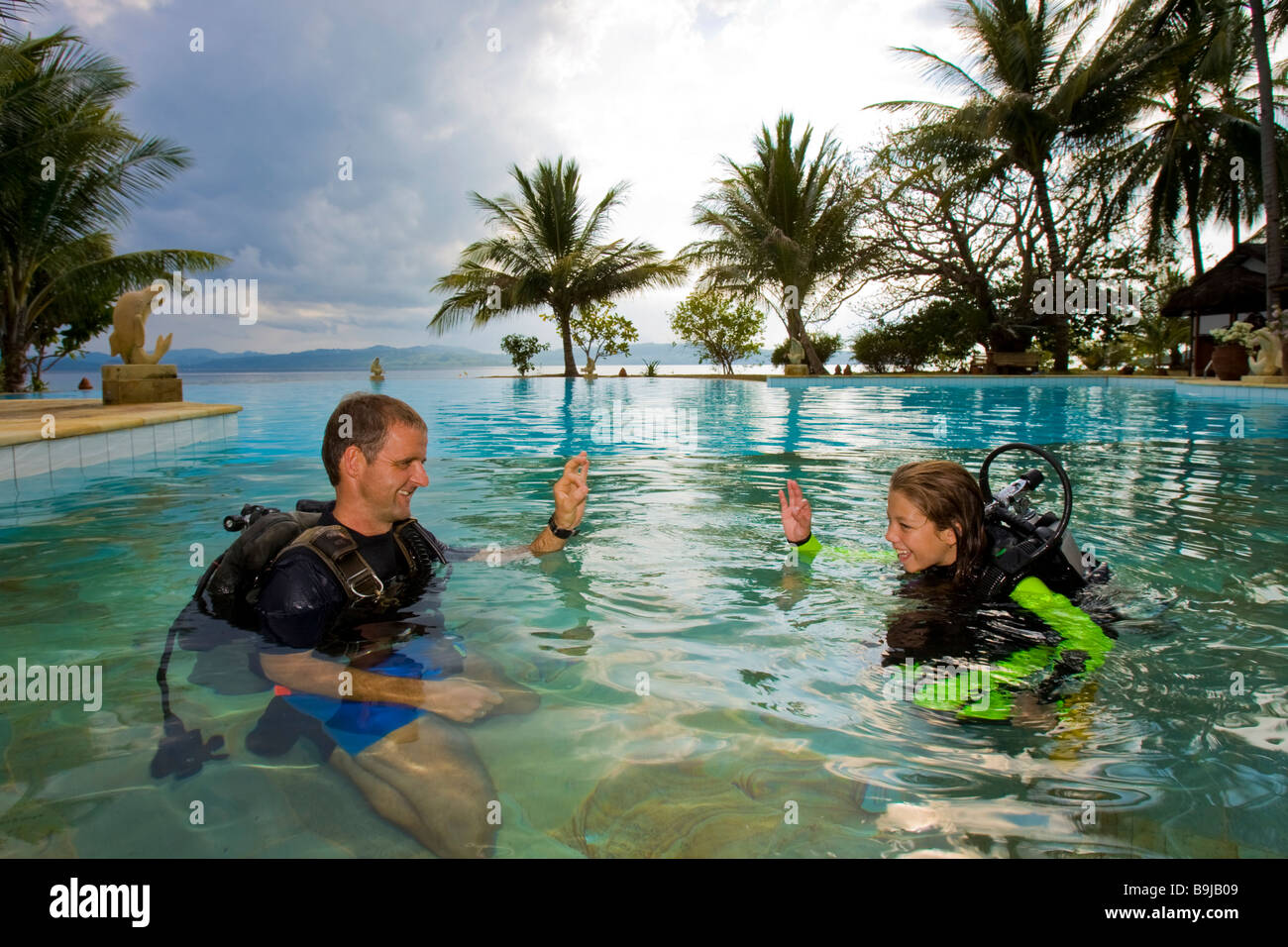 Scuba diving teacher giving a girl a lesson in a swimming pool ...