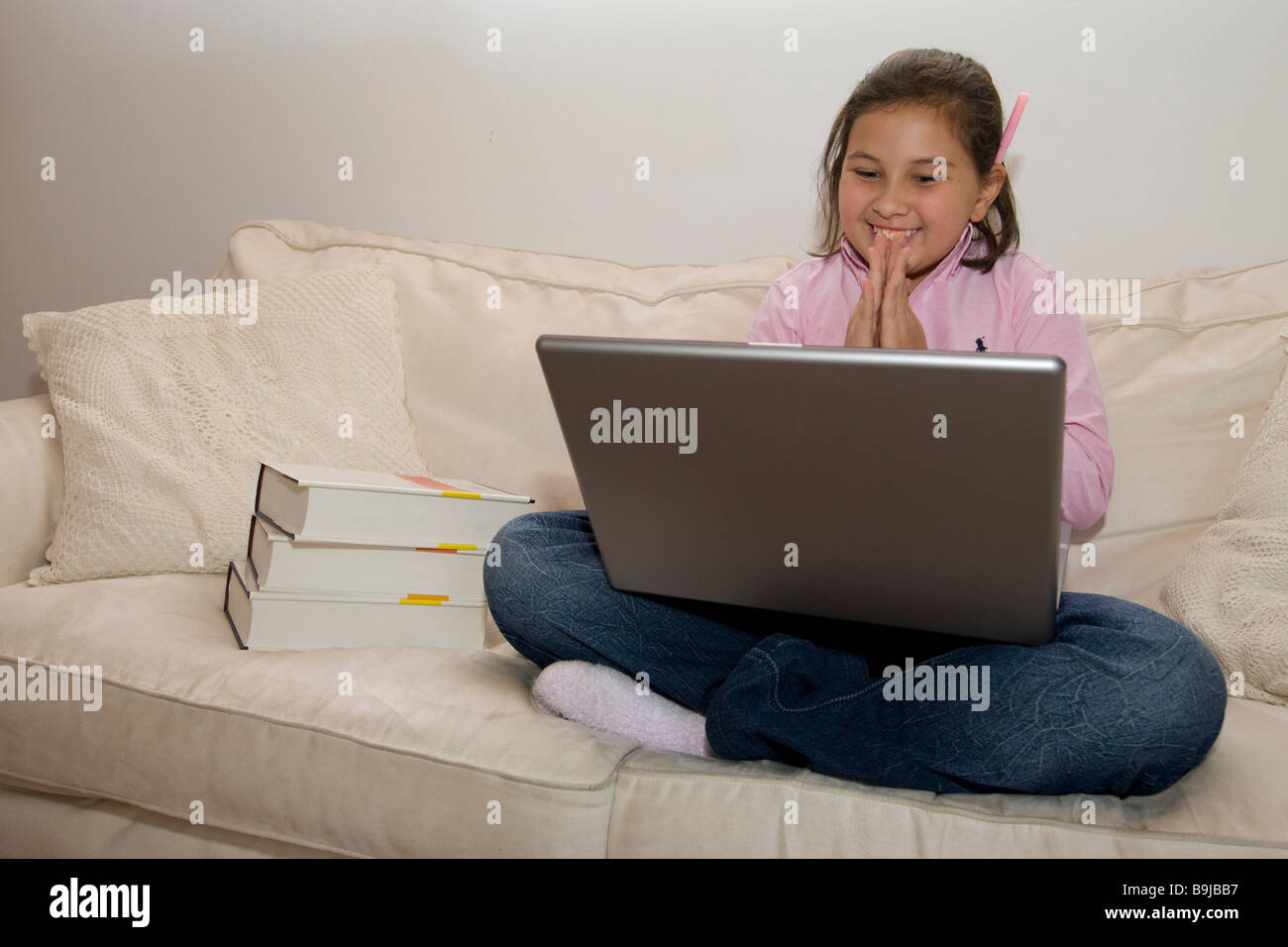 Student, approx. 11 years old, working on a laptop is pleased Stock Photo