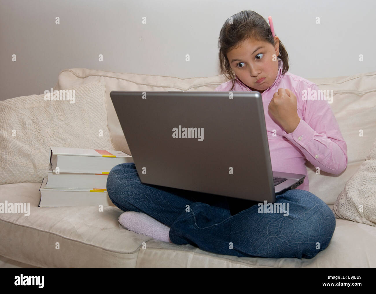 Student, approx. 11 years old, working on a laptop is getting angry Stock Photo