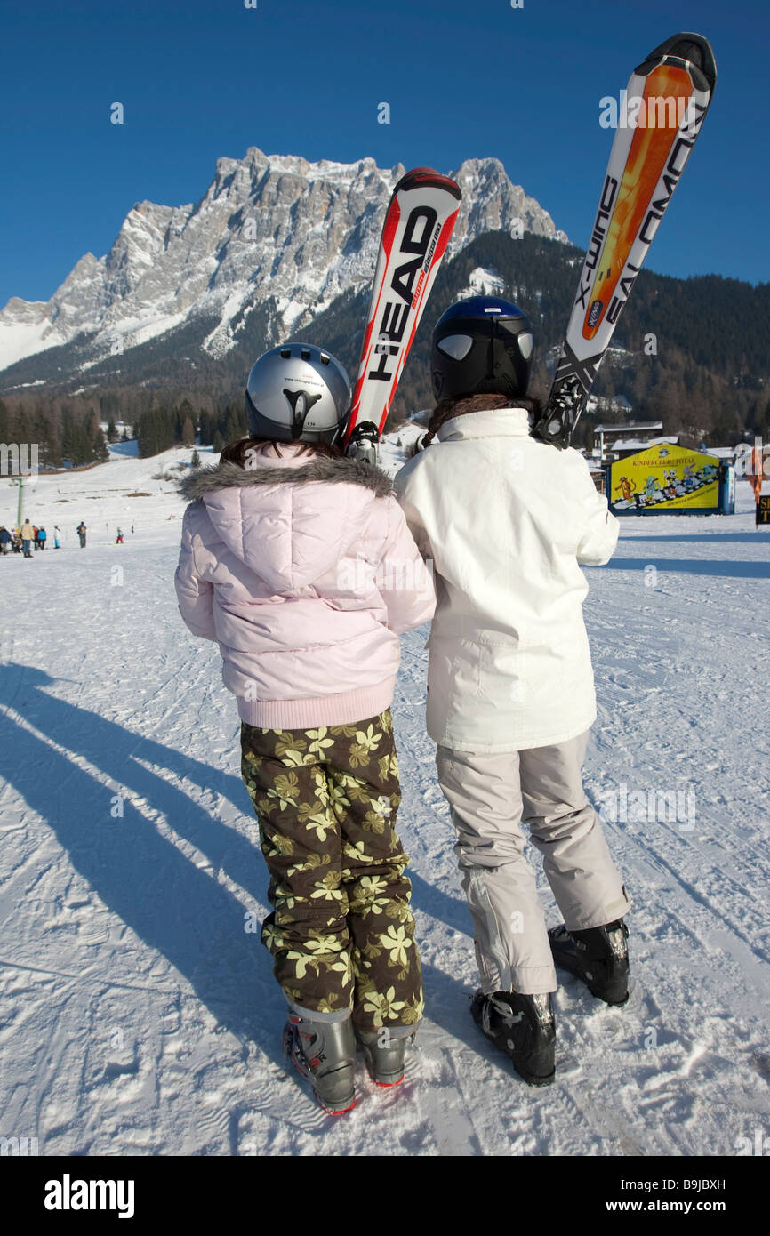 Two female skiers looking towards Zugspitze mountain, Tyrol, Austria, Europe Stock Photo