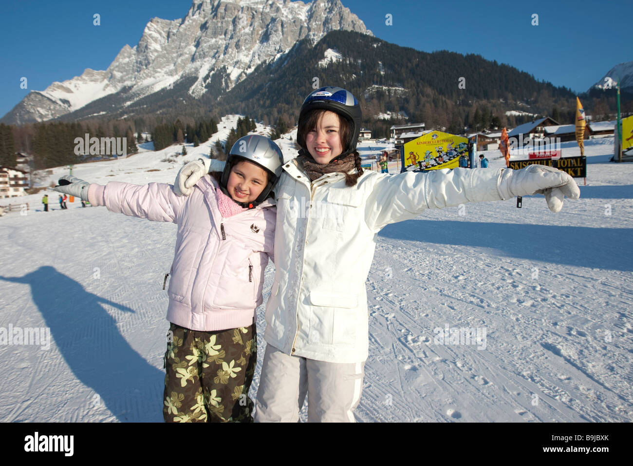 Two female skiers standing happily on the ski slopes in front of Zugspitze mountain, Tyrol, Austria, Europe Stock Photo