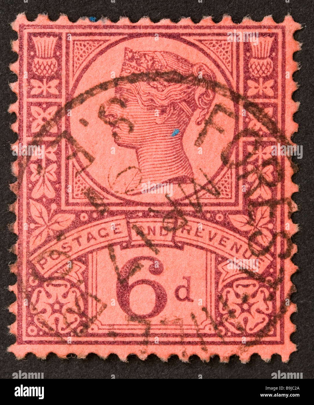 Close up of British Victorian 6d postage stamp on black background