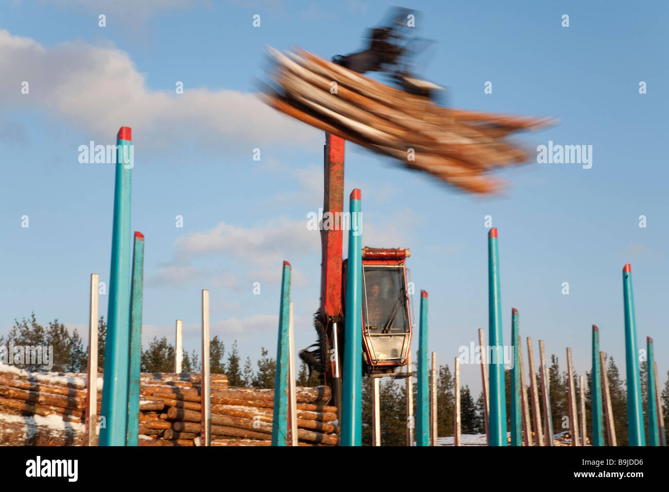log-truck-driver-using-truck-crane-and-loading-logs-to-cargo-log-train-cars-at-railroad-depot-at