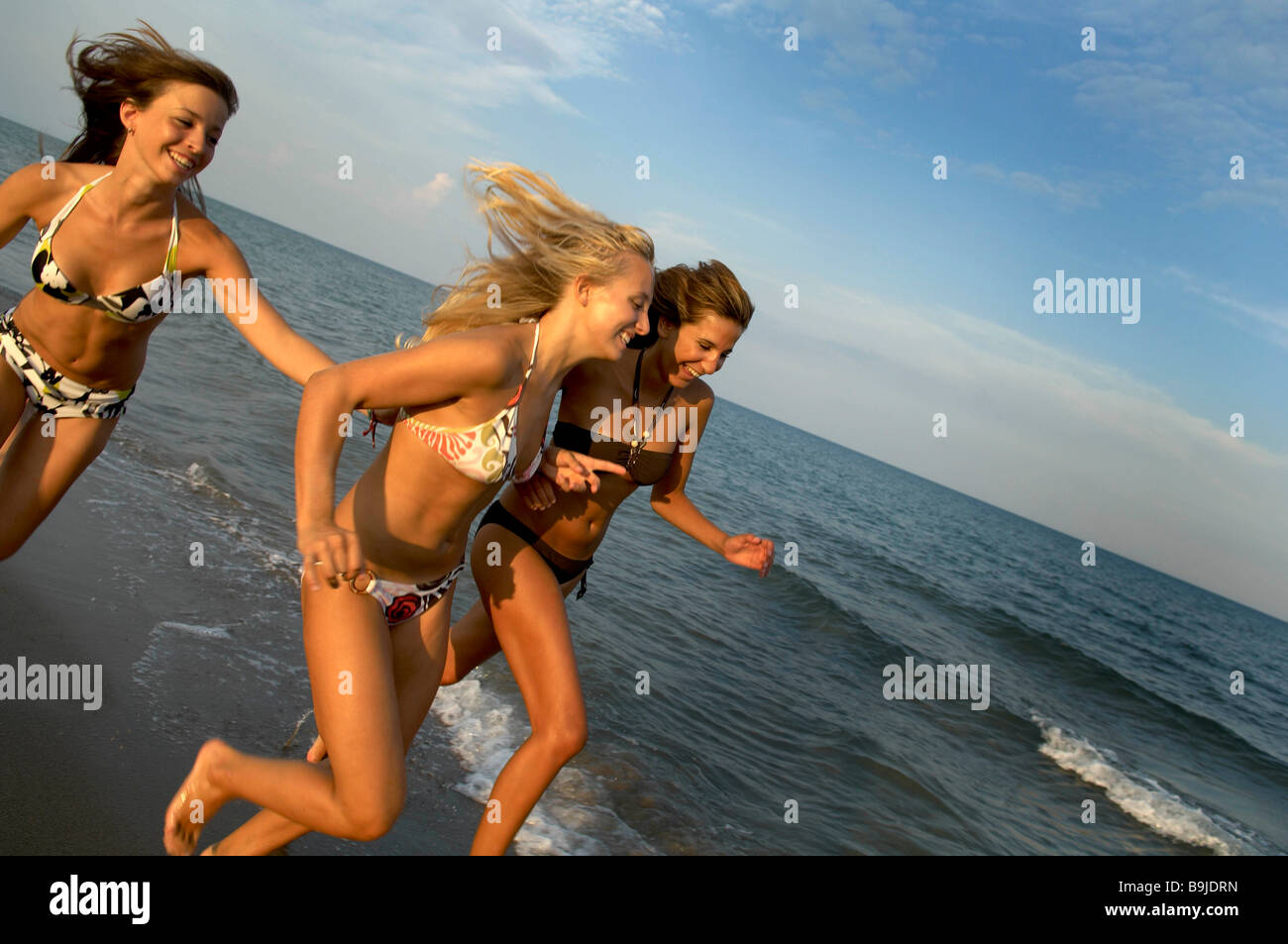 Girl teenagers running on the beach Stock Photo