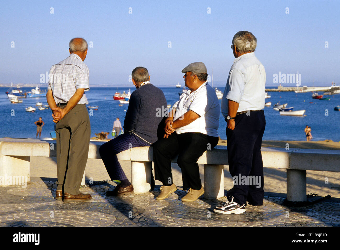 Porto de Pesca, old men looking out to sea, boats at the harbour of Cascais, a fishing village, grown together with Estoril, Li Stock Photo
